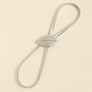 Detailed macro view of an elastic silver belt featuring delicate metal leaf-shaped buckles