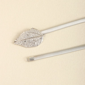 Detailed macro view of silver metal leaf buckle on minimalist elastic waist chain belt
