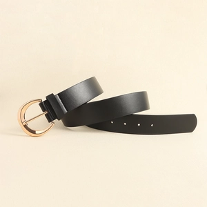 Close-up of matte black leather belt featuring a polished gold horseshoe metal buckle