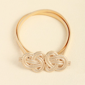 Detail of golden elastic metal belt with elegant interlocking knotted rope buckle texture