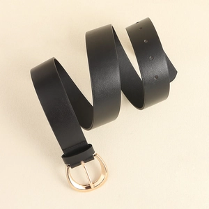 Detail of black leather belt with a polished rose gold D-ring buckle and round adjustment holes