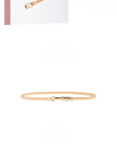 Close-up of golden elastic metal skinny belt featuring an adjustable square buckle