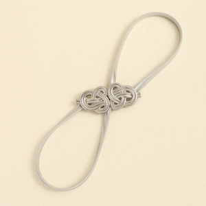 Macro shot of silver elastic metal waist chain featuring an intricate knot buckle design