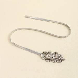 Detail of silver elastic metal spring belt featuring a textured knot-style buckle design