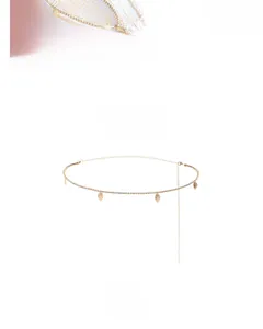 Detailed close-up of golden leaf pendant waist chain with sparkling rhinestones decoration