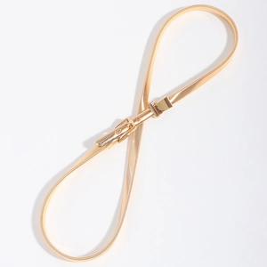 Close-up of golden elastic snake chain waist belt with adjustable buckle for dresses
