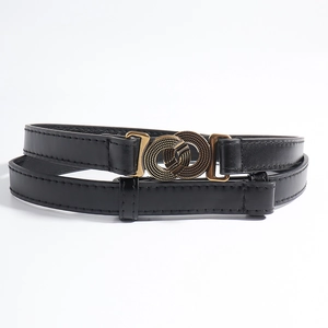 Detail van de vintage gouden dubbele ringgesp met textuur op zwarte lederen riem