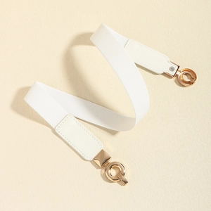 Détail d'une ceinture élastique blanche avec boucles dorées et finitions en cuir