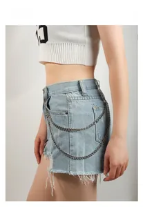 Double-layered metal waist chain accessory styled on light blue frayed denim shorts