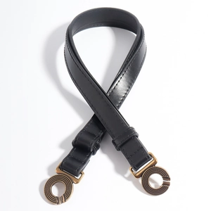 Detail van vintage dubbele ring bronzen gesp op zwarte leren riem voor jurken