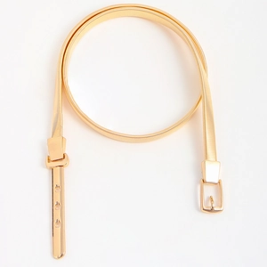 Detailed view of elastic gold metal skinny belt with polished buckle for dresses