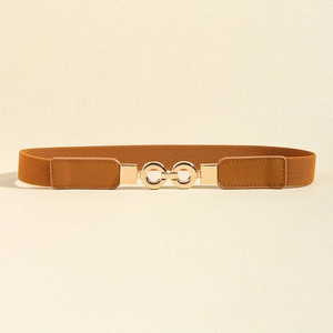 Détail de la ceinture élastique marron caramel avec boucle à double anneau doré entrelacé