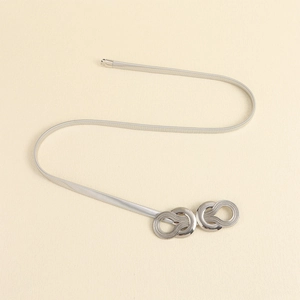 Detail of silver elastic metal chain belt with interlocking dual-ring geometric buckle
