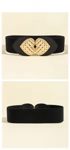Detail view of the textured golden heart buckle on a black elastic wide waist belt