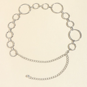 Detail eines silbernen Metallketten-Gürtels mit Ringen und dekorativer kleiner Kugel