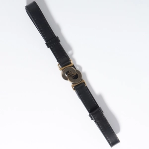 Detail van de vintage gouden dubbele ringgesp en zwarte imitatieleren riem met stiksels