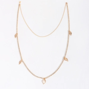 Detail of golden waist chain with sparkling rhinestones and delicate metal leaf pendants