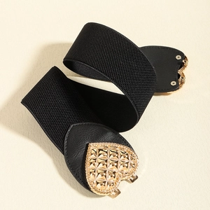 Close-up of women's black elastic waist belt with textured gold heart buckle detail