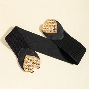 Close-up of golden heart-shaped metal buckles on a black elastic wide waist belt