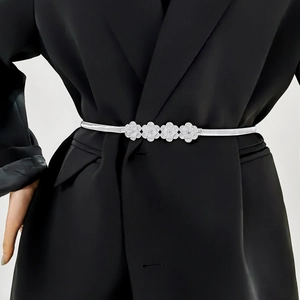 Detail view of elastic silver flower belt with rhinestones on a black blazer
