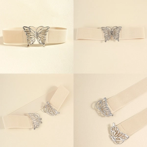 Detail of beige elastic waist belt with an intricate silver hollow butterfly buckle closure