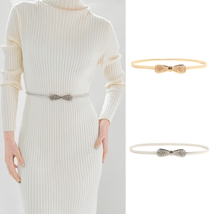 Detail of slim elastic metal waist chain with rhinestone bow buckle in gold and silver