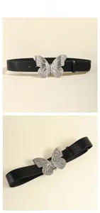 Vue détaillée de la boucle papillon en argent sur une ceinture en cuir noir chic