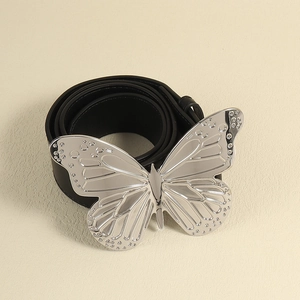 Détail d'une grande boucle papillon argentée sur une ceinture punk en cuir pour femme