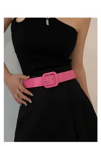 Detail of bright pink waist belt with large square buckle on a black dress outfit