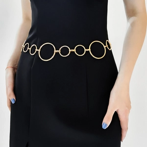 Detailaufnahme des eleganten goldenen Kettenmürtels mit Rundgliedern auf schwarzem Kleid