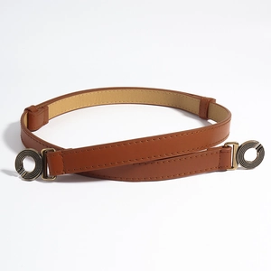 Detailopname van bruine lederen riem met dubbele ronde getextureerde metalen gespen