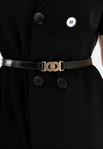 Detailopname van de gouden dubbele ringgesp op een slanke zwarte lederen riem