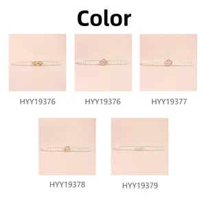 Detailed close-up of five different rhinestone flower and bow buckle styles on pearl waist chains