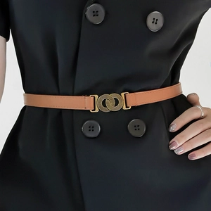 Detail van vintage bruine leren riem met dubbele gouden gesp op zwarte jurk