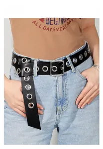 Close-up of black punk belt with silver metal eyelets on light blue denim jeans