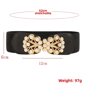 Dettaglio di cintura elastica da 6 cm con fibbia a foglia dorata e perle finte bianche
