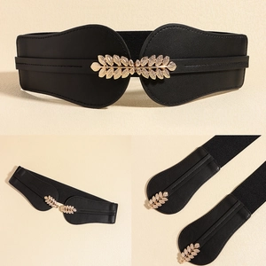Detail of black elastic wide waist belt featuring a decorative golden leaf metal buckle