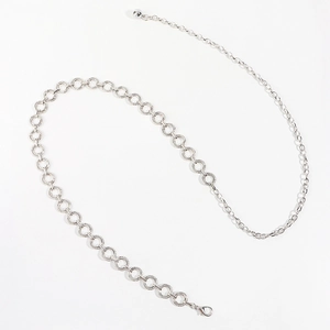 Detail of silver textured metal rings on a minimalist waist chain with lobster clasp