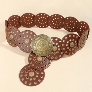 Détail de la ceinture marron vintage avec œillets métalliques et boucle fleurie
