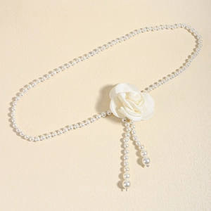 Detail of elegant pearl waist chain featuring a white silk camellia flower and hanging tassels