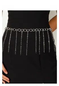 Détail de la ceinture chaîne en métal argenté avec pampilles sur une robe noire