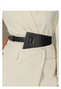 Détail d'une large ceinture noire en cuir PU avec design géométrique sur un manteau beige
