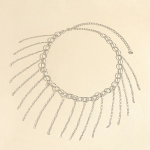 Détail d'une élégante chaîne de taille en métal argenté avec pompons et fermoir réglable