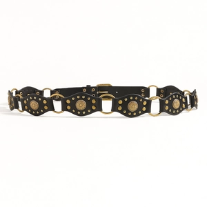 Dettaglio cintura Y2K in pelle nera con borchie dorate e dischi metallici decorati