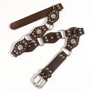 Dettaglio della cintura vintage marrone scuro con anelli in argento e borchie in metallo