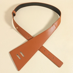 Détail d'une ceinture large en cuir PU marron caramel avec bouton pression doré et couture