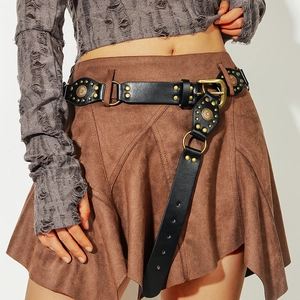 Dettaglio della cintura borchiata vintage Y2K con anello in metallo e nappa in pelle