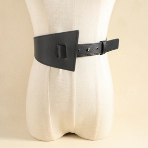 Détail d'une large ceinture noire en similicuir avec boucle géométrique dorée
