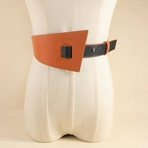 Détail d'une large ceinture marron et noire avec des panneaux géométriques et boucle en métal