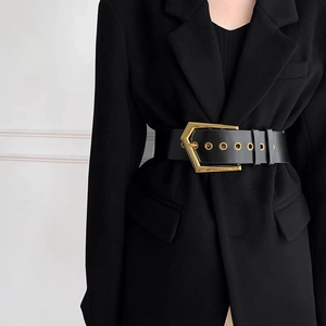 Detail of wide black PU leather waist belt featuring a gold geometric pentagon buckle